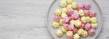 Beyaz ahşap arka plan üzerinde bir tabak üzerinde Mini bezeler, üst görünümü