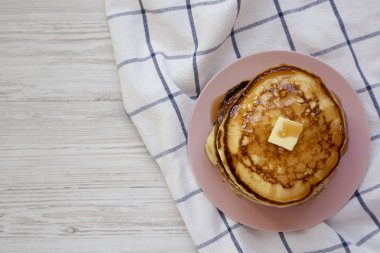 Pembe bir tabak üzerinde tereyağı ve akçaağaç şurubu ile ev yapımı krep, t