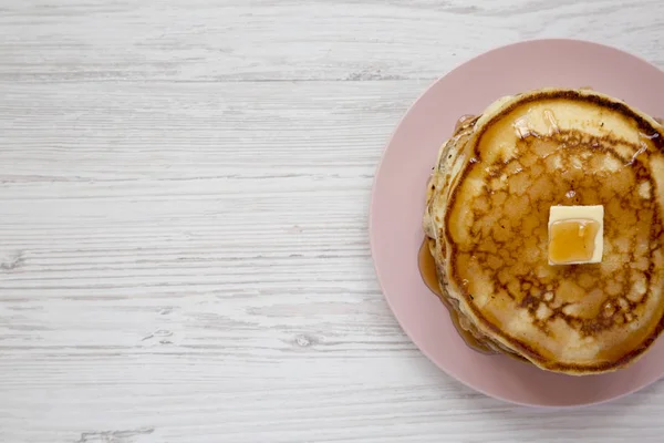 Hausgemachte Pfannkuchen mit Butter und Ahornsirup auf einem rosa Teller, — Stockfoto