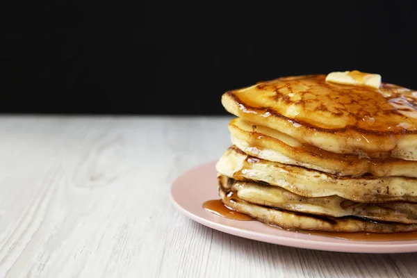 Hausgemachte Pfannkuchen mit Butter und Ahornsirup auf einem rosa Teller, — Stockfoto