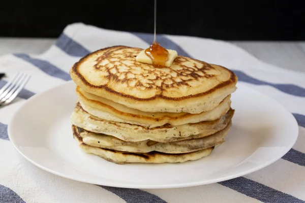 Hausgemachte Pfannkuchen mit Butter und Ahornsirup auf einem rosa Teller, — Stockfoto