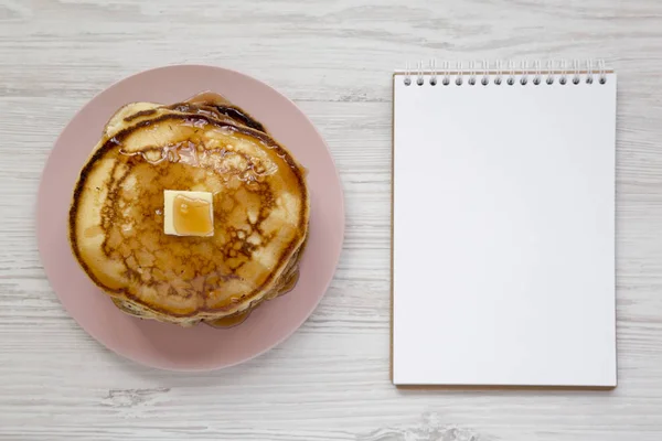 Hausgemachte Pfannkuchen mit Butter und Ahornsirup auf einem rosa Teller, — Stockfoto