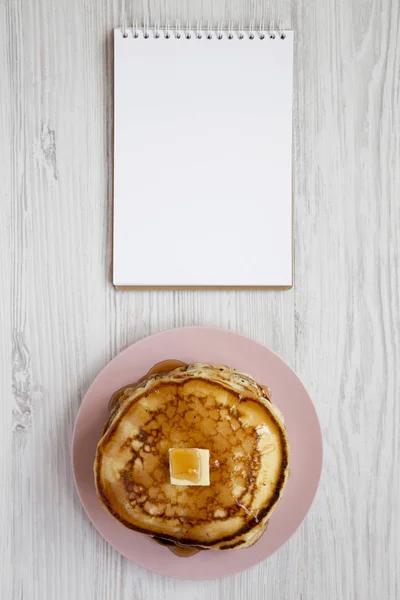 Hausgemachte Pfannkuchen mit Butter und Ahornsirup auf einem rosa Teller, — Stockfoto