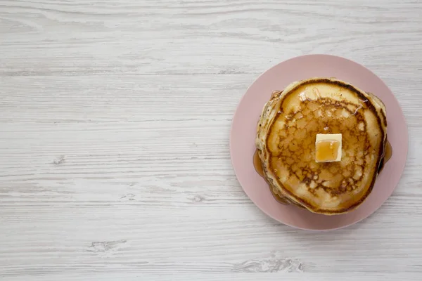 Hausgemachte Pfannkuchen mit Butter und Ahornsirup auf rosa Teller, v — Stockfoto