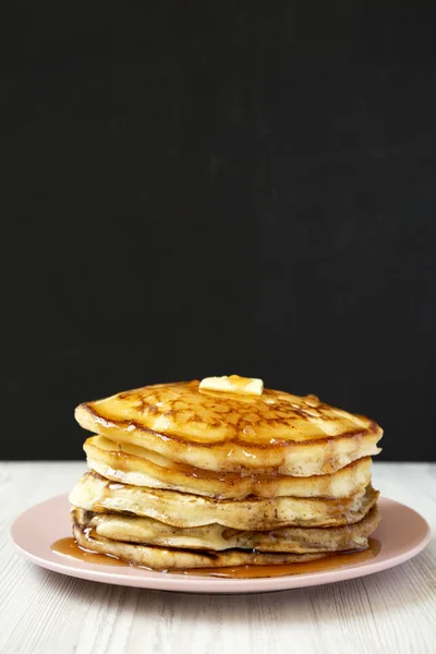 Hausgemachte Pfannkuchen mit Butter und Ahornsirup auf einem rosa Teller, — Stockfoto