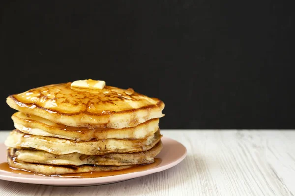 Hausgemachte Pfannkuchen mit Butter und Ahornsirup auf einem rosa Teller, — Stockfoto