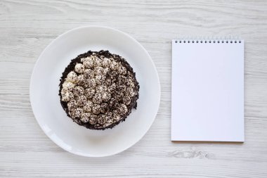 Beyaz bir tabak, bir whit üzerinde boş not defteri üzerinde ev yapımı tiramisu kek