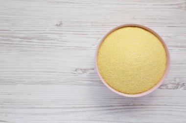 Beyaz ahşap surfac üzerinde pembe bir kapta kuru irmik durum unu