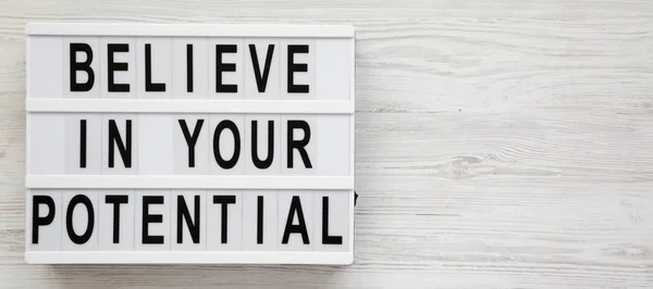 'Cree en tu potencial' palabras en una caja de luz en un bosque blanco —  Fotos de Stock