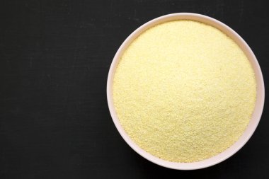 Kuru irmik durum unu siyah arka plan üzerinde pembe bir kapta, t