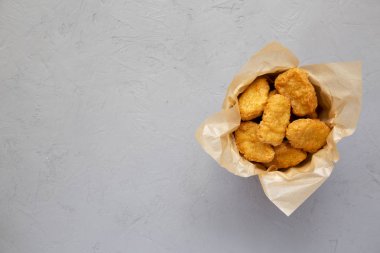 Beton arka plan üzerinde bir kağıt kutusunda tavuk nuggets. Overhea