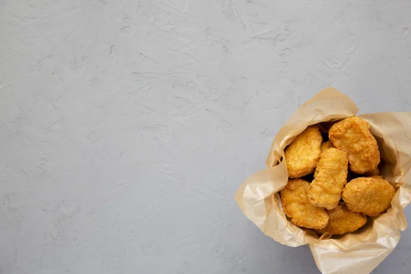 Nuggets de pollo en una caja de papel, ketchup sobre un fondo de hormigón — Foto de Stock