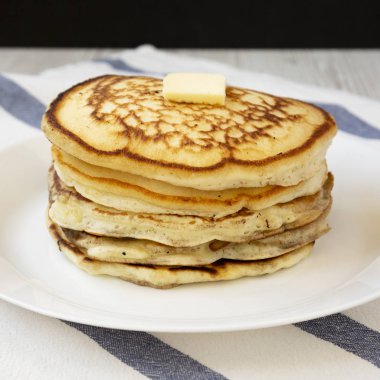 Beyaz bir tabak, yan görünüm üzerinde tereyağı ile ev yapımı krep. Yakın