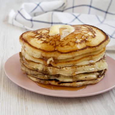 Pembe bir tabak üzerinde tereyağı ve akçaağaç şurubu ile ev yapımı krep, s