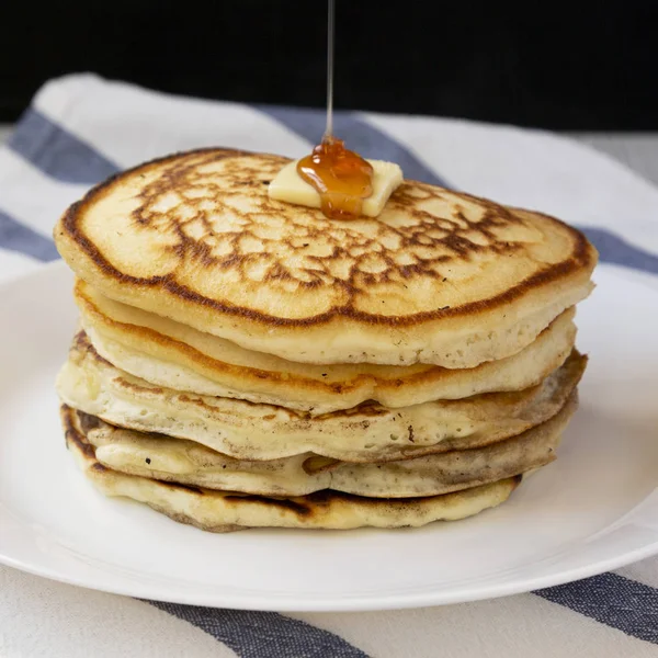 Hausgemachte Pfannkuchen mit Butter und Ahornsirup auf einem weißen Teller, — Stockfoto