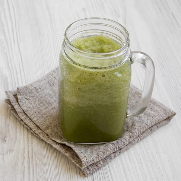 Green celery smoothie in a glass jar over white wooden surface, — Stock Photo, Image