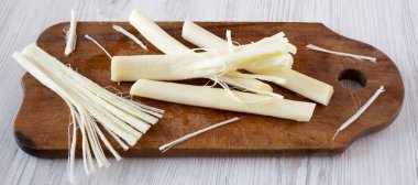 Beyaz ahşap backgro üzerinde rustik ahşap tahta üzerinde String peynir