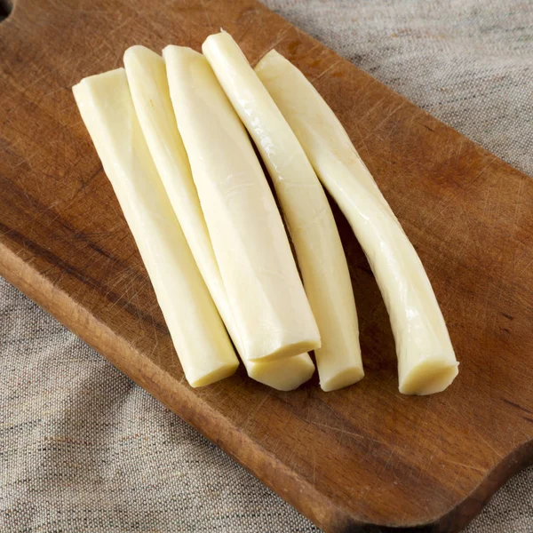 String cheese on a rustic wooden board, low angle view. Healthy — Stock Photo, Image