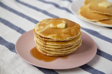 Pembe üzerine tereyağı ve akçaağaç şurubu ile ev yapımı krep Yığını