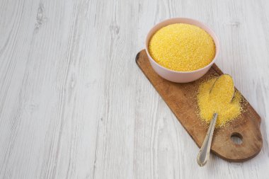 Beyaz ahşap üzerinde pembe bir kapta kuru organik Masarepa mısır unu 