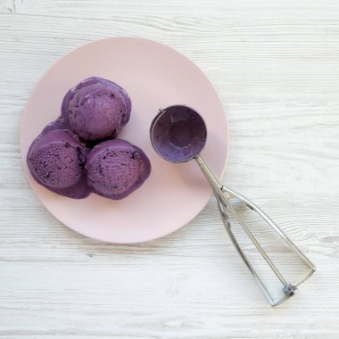 Pembe bir plaka ov üzerinde dondurma kepçe ile Yaban mersini dondurma topları