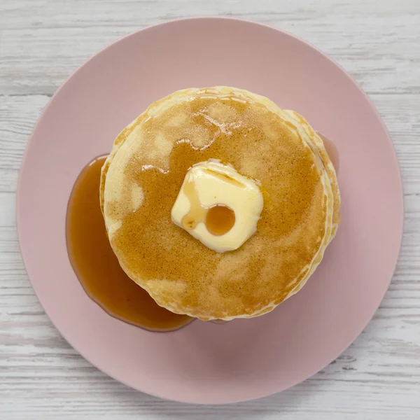 Stapel hausgemachter Pfannkuchen mit Butter und Ahornsirup auf einem rosa — Stockfoto