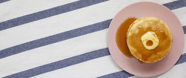 Stapel hausgemachter Pfannkuchen mit Butter und Ahornsirup auf einem rosa — Stockfoto