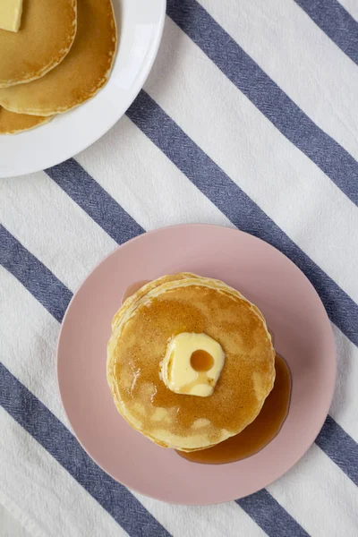 Stapel hausgemachter Pfannkuchen mit Butter und Ahornsirup auf einem rosa — Stockfoto