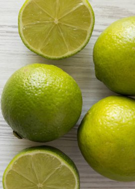 Beyaz ahşap bir masa üzerinde yeşil narenciye kireç, havai görünümü. Kaynak 