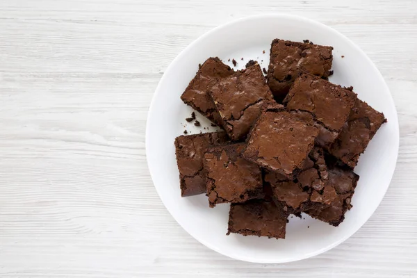 Top view, homemade chocolate brownies on a white plate on a whit — Stock Photo, Image