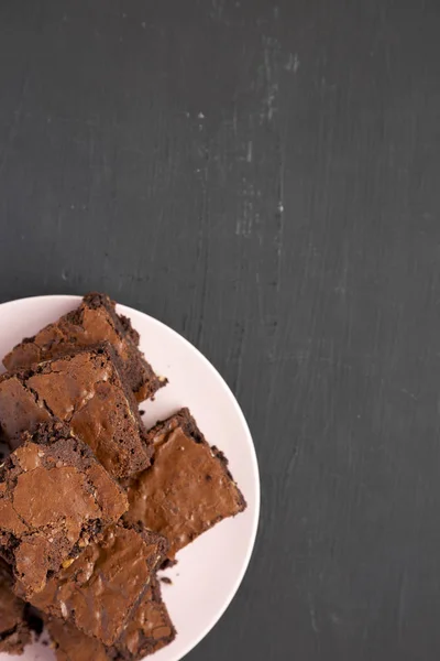 Homemade chocolate brownies on a pink plate on a black backgroun — Stock Photo, Image