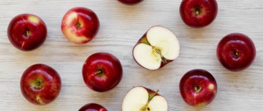 Beyaz ahşap arka plan üzerinde ham kırmızı elma, üst görünümü. Düz yatıyordu,