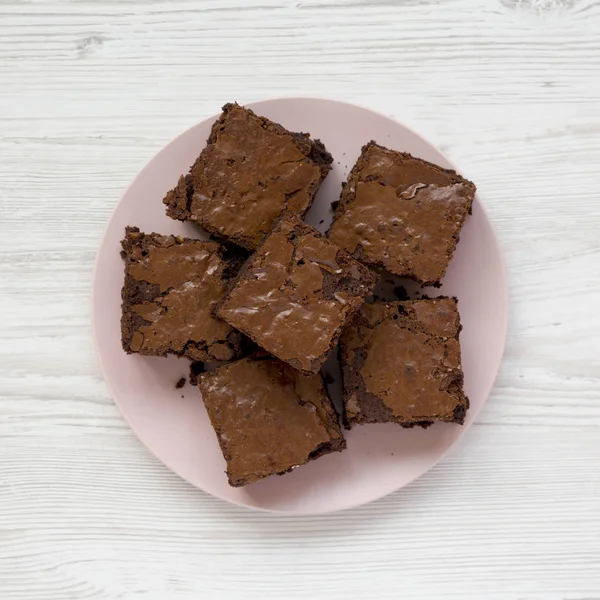 Homemade chocolate brownies on a pink plate on a white wooden ba — Stock Photo, Image