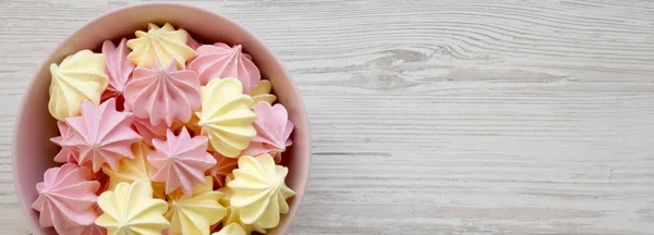 Mini merengues en un cuenco rosa sobre fondo de madera blanca, sobre — Foto de Stock