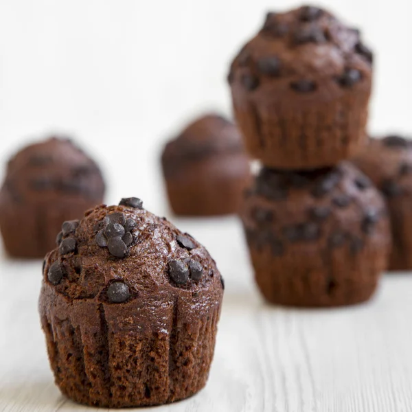 Schokoladenmuffins auf einem weißen Holztisch, Seitenansicht. Nahaufnahme. — Stockfoto
