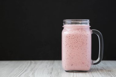 Cam bir kavanozda çilekli muz smoothie, yan görünüm. Alan için 