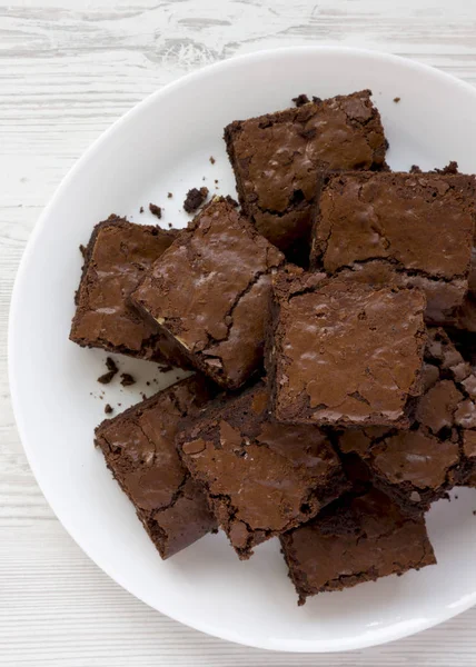 Homemade chocolate brownies on a white plate on a white wooden s — Stock Photo, Image