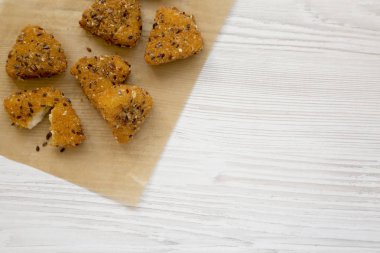 Beyaz ahşap bir yüzey üzerinde bir fırın tepsisine kızarmış camembert. Fla