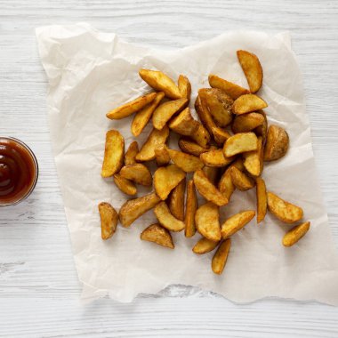 Kızarmış patates dilimleri bir beyaz tahta backgr barbekü sosu ile