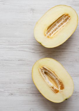 Beyaz ahşap arka planda kavun iki yarısı, üst görünüm. Kaynak
