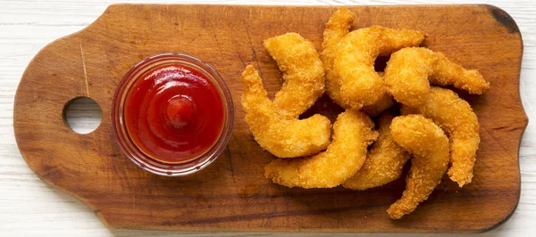 Fried shrimps tempura with sauce on a rustic wooden board, top v