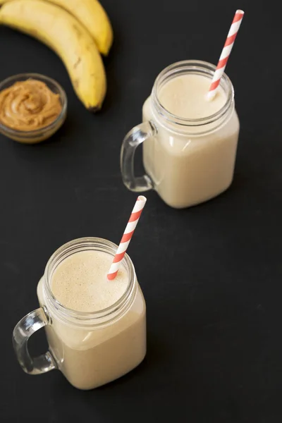 Mangkuk kaca Mason diisi dengan selai kacang pisang smoothie o — Stok Foto