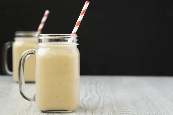 Batido de plátano con mantequilla de maní en jarras de vidrio, vista lateral. Copiar — Foto de Stock