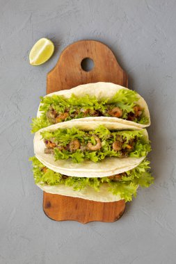 Gri bir arka planda rustik ahşap tahta üzerinde karides Taco, üst 