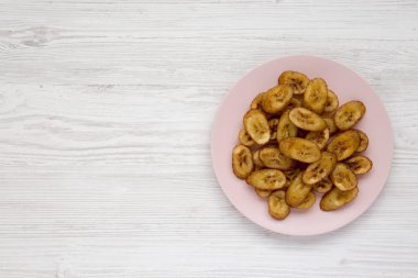 Üst görünüm, beyaz bir pembe plaka üzerinde ev yapımı kızarmış plantain Wo