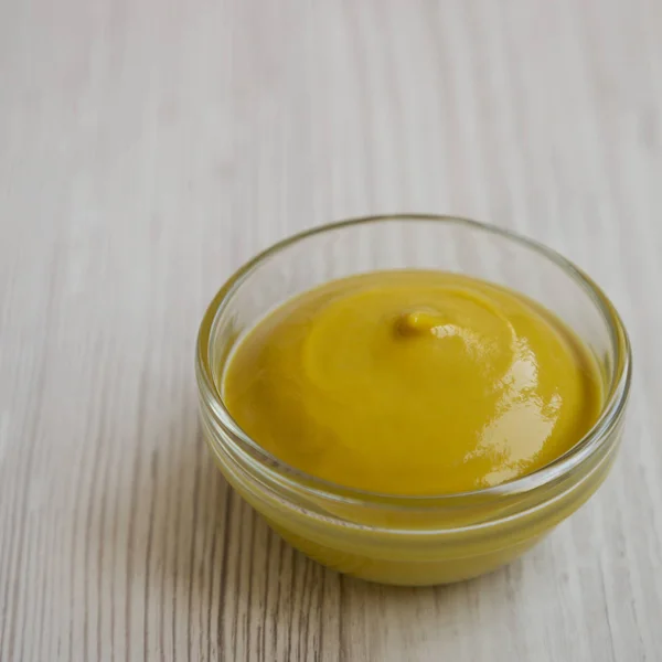 Homemade organic mustard in a glass bowl on a white wooden surfa — Stock Photo, Image