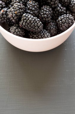 Siyah bir masada pembe bir kase böğürtlen, yan görünüm. Yaz 