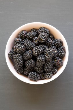 Siyah yüzey üzerinde pembe bir kase böğürtlen, üst görünüm. Yaz