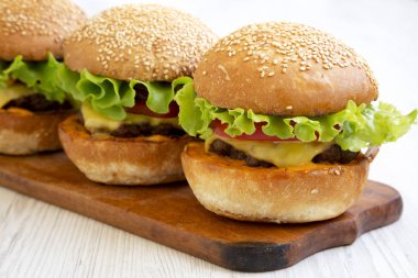 Rustik ahşap tahta üzerinde ev yapımı Cheeseburgerler, yan manzaralı. Clos
