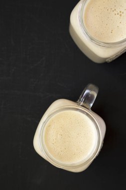 Siyah bir yüzey üzerinde cam kavanoz fıstık ezmesi muz yüzlü, 